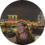 Woman laughing with Marina Bay Sands skyline at night in Singapore