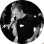 Man singing into a microphone indoors, black and white performance shot