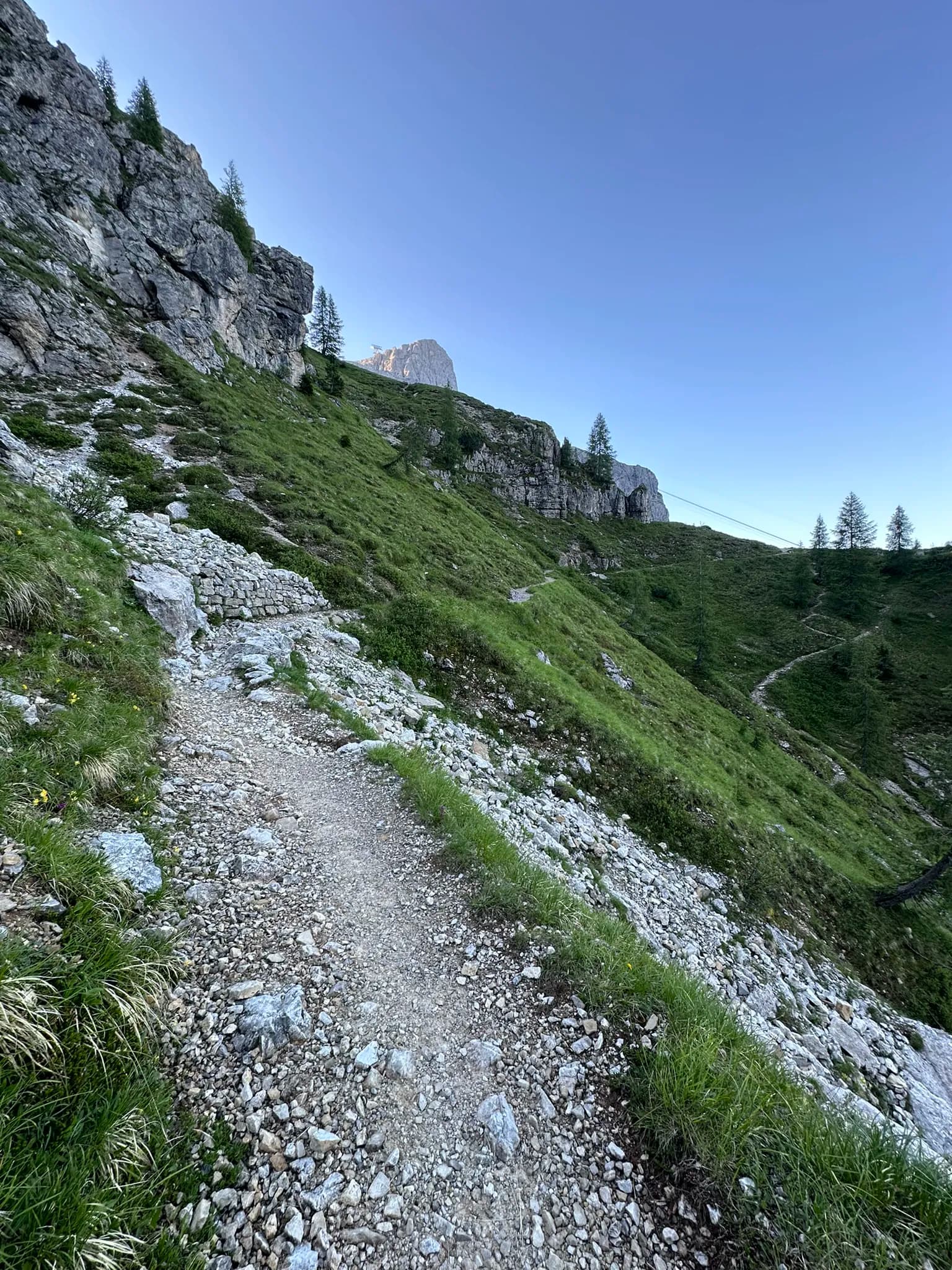Hiking trail on a grassy mountain slope in the Pale di San Martino range.