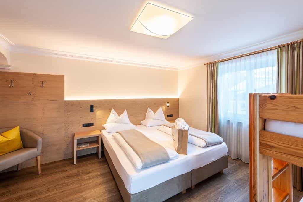 Hotel room interior with double bed and wooden headboard at Hotel Gran Fanes