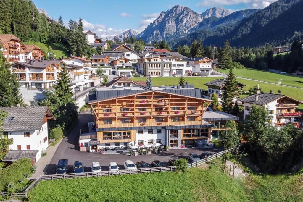 Hotel building with wooden balconies in alpine village with mountains